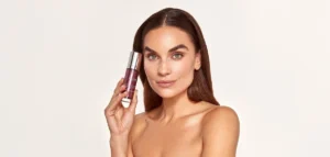 Woman holding a premium facial serum bottle, showcasing luxury skincare usage and modern beauty routines focused on skin health and self-care.