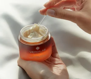 Hand holding Verdilab Switzerland Natural Glow Vitamin C brightening cream with dropper applicator.